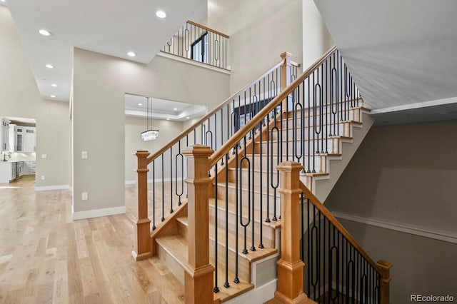 16250 Kenosha St, Brighton, CO 80603 - staircase with a tray ceiling, wood finished floors, recessed lighting, baseboards, and a towering ceiling