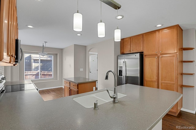 kitchen featuring a center island, dark hardwood / wood-style floors, stainless steel appliances, sink, and hanging light fixtures