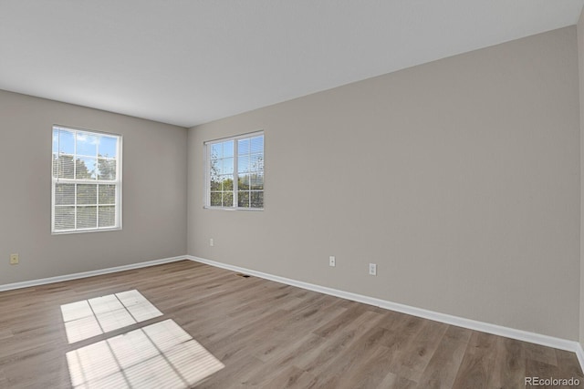 unfurnished room with plenty of natural light and light hardwood / wood-style floors