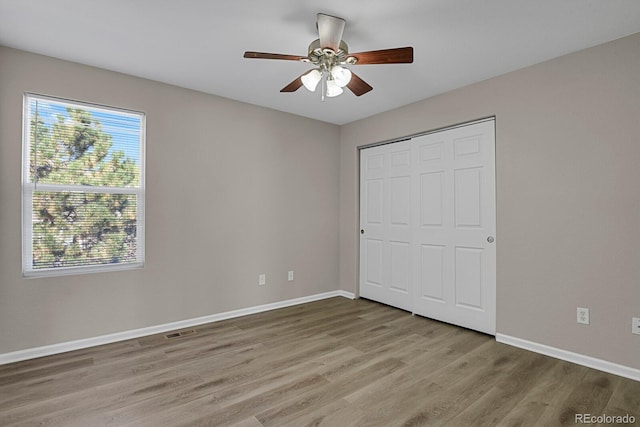 unfurnished bedroom with a closet, light hardwood / wood-style flooring, and ceiling fan