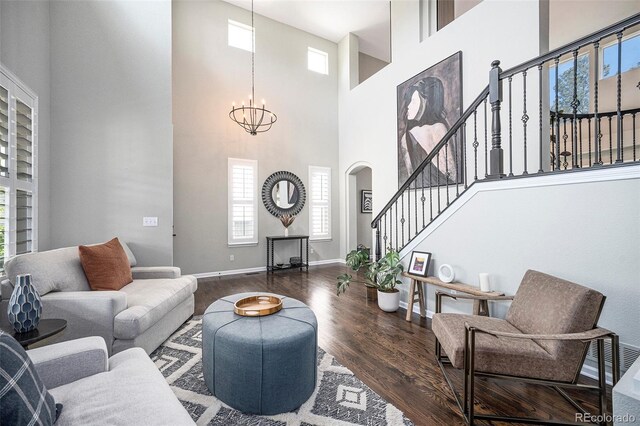 8548 Winter Berry Dr, Castle Pines, CO 80108 - living area with a high ceiling, wood finished floors, stairway, a chandelier, and baseboards