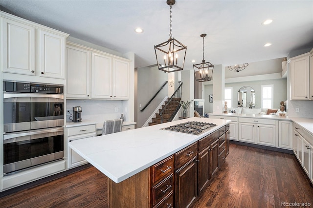 8548 Winter Berry Dr, Castle Pines, CO 80108 - kitchen with appliances with stainless steel finishes, light countertops, recessed lighting, a chandelier, and dark wood-style floors