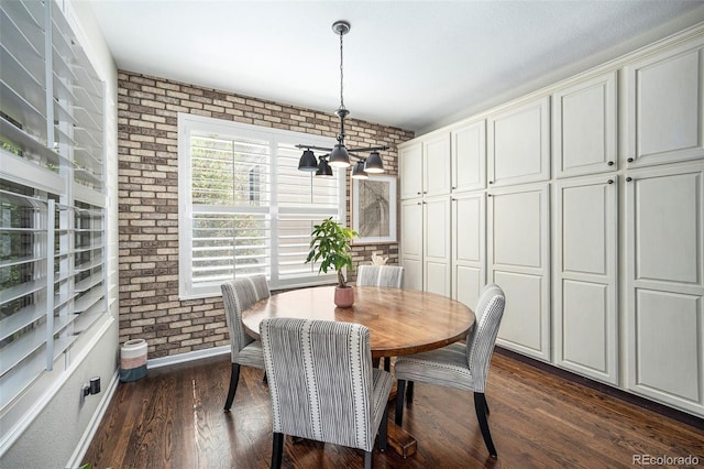8548 Winter Berry Dr, Castle Pines, CO 80108 - dining space with brick wall, dark wood-style flooring, a chandelier, and baseboards