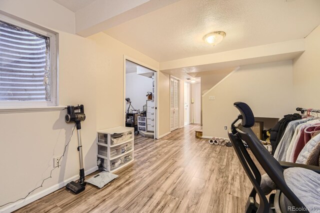14193 E Radcliff Cir, Aurora, CO 80015 - exercise area featuring light wood-style flooring, baseboards, and a textured ceiling