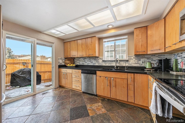 kitchen featuring stainless steel appliances, tasteful backsplash, and sink