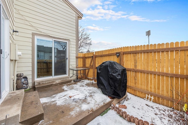 snow covered patio featuring a grill