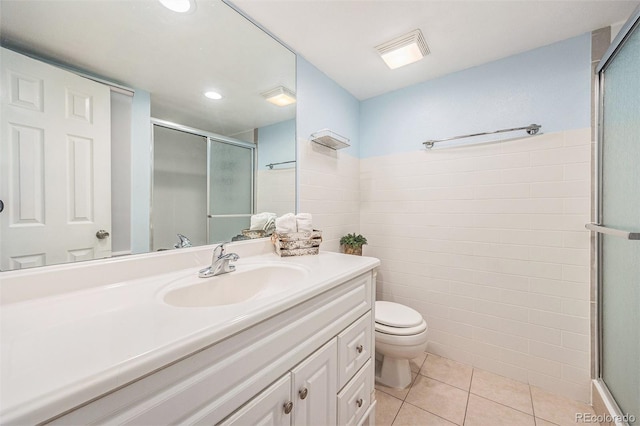 bathroom with visible vents, toilet, vanity, a shower stall, and tile patterned floors