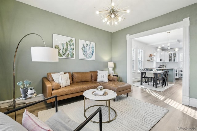 living room with an inviting chandelier and light hardwood / wood-style flooring