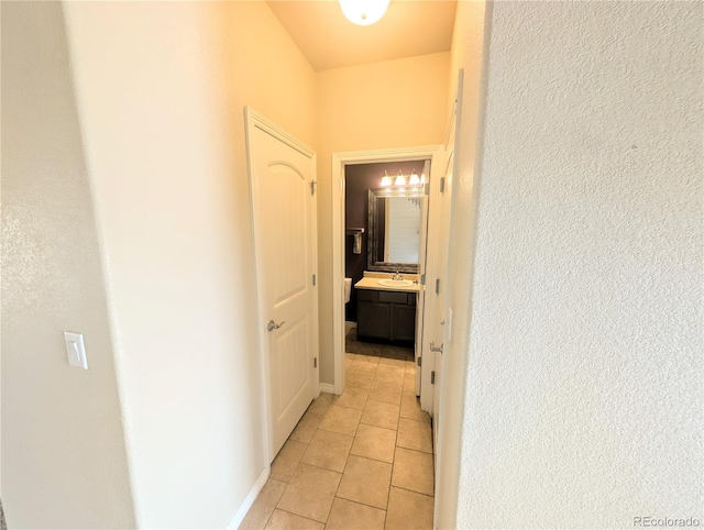 7958 Lightwood Way, Colorado Springs, CO 80908 - corridor with light tile patterned floors, a textured wall, and a sink