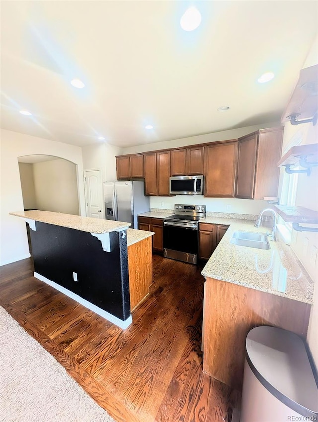 7958 Lightwood Way, Colorado Springs, CO 80908 - kitchen with appliances with stainless steel finishes, a sink, a kitchen island, a breakfast bar, and light stone countertops