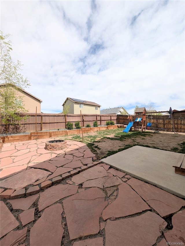 7958 Lightwood Way, Colorado Springs, CO 80908 - fenced backyard featuring a fire pit, a playground, and a patio area