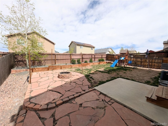 7958 Lightwood Way, Colorado Springs, CO 80908 - fenced backyard featuring a fire pit, a patio area, and a playground