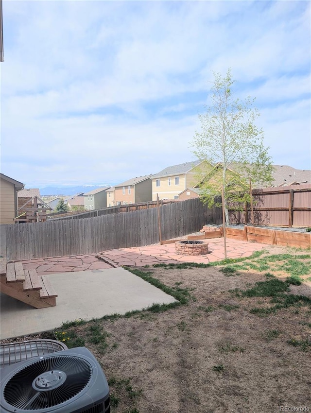 7958 Lightwood Way, Colorado Springs, CO 80908 - fenced backyard with a fire pit, a patio area, cooling unit, and a residential view
