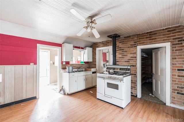 7080 S Calhan Rd, Calhan, CO 80808 - kitchen featuring a sink, a wood stove, light wood-style flooring, and gas range gas stove