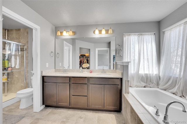 bathroom with a sink, double vanity, a stall shower, and a garden tub