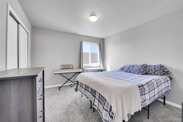 carpeted bedroom with a closet, baseboards, and a textured ceiling