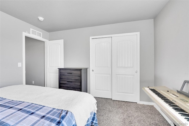 carpeted bedroom featuring a closet, baseboards, and visible vents