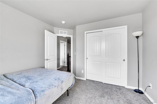 carpeted bedroom featuring a closet, visible vents, and baseboards