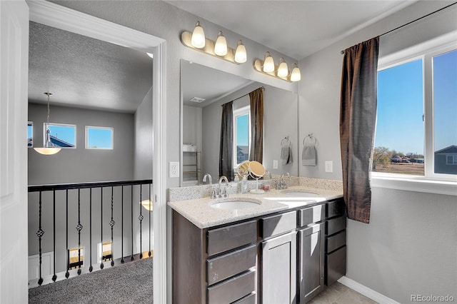 bathroom featuring double vanity, a sink, and baseboards