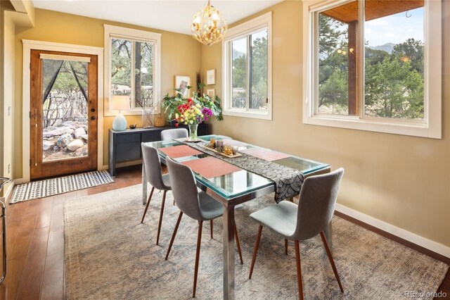 147 Moonlight Way, Crestone, CO 81131 - dining space featuring a chandelier, hardwood / wood-style floors, and baseboards