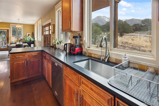 147 Moonlight Way, Crestone, CO 81131 - kitchen featuring stainless steel dishwasher, a sink, dark countertops, a chandelier, and plenty of natural light