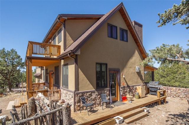 147 Moonlight Way, Crestone, CO 81131 - back of house featuring stucco siding, stone siding, a balcony, and a deck