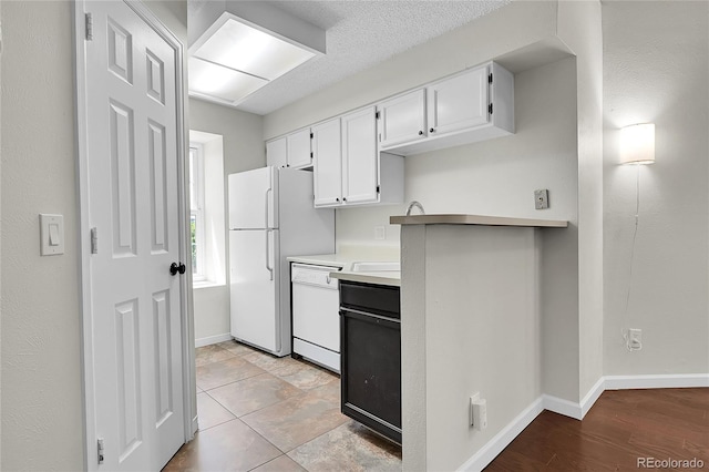 kitchen featuring white appliances, white cabinets, light countertops, and baseboards