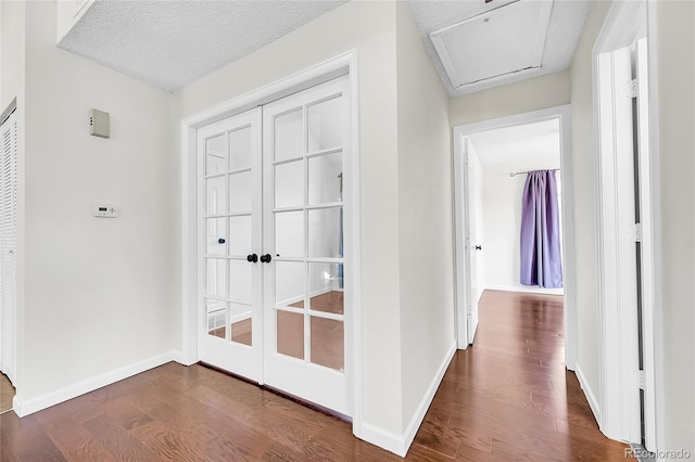 hallway with dark wood-type flooring, baseboards, and french doors