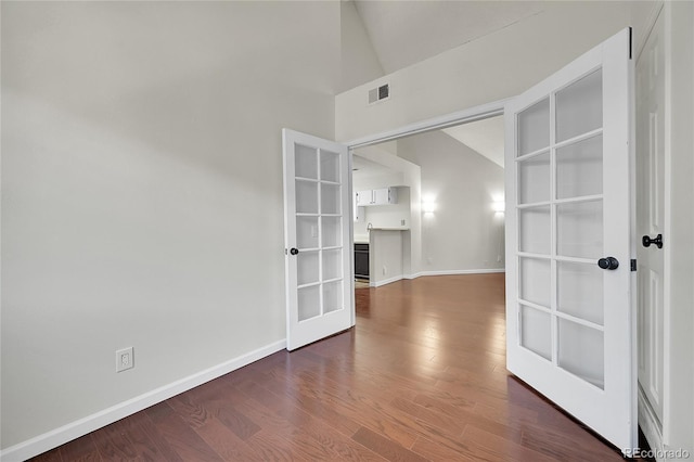 unfurnished room with french doors, baseboards, wood finished floors, and high vaulted ceiling