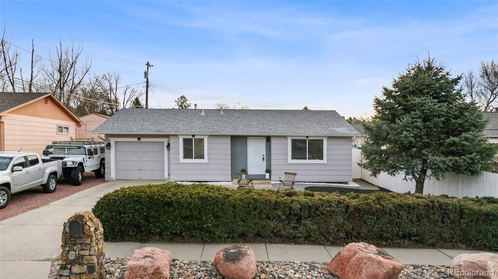 1025 N 19th St, Colorado Springs, CO 80904 - ranch-style home with fence, driveway, a shingled roof, and a garage