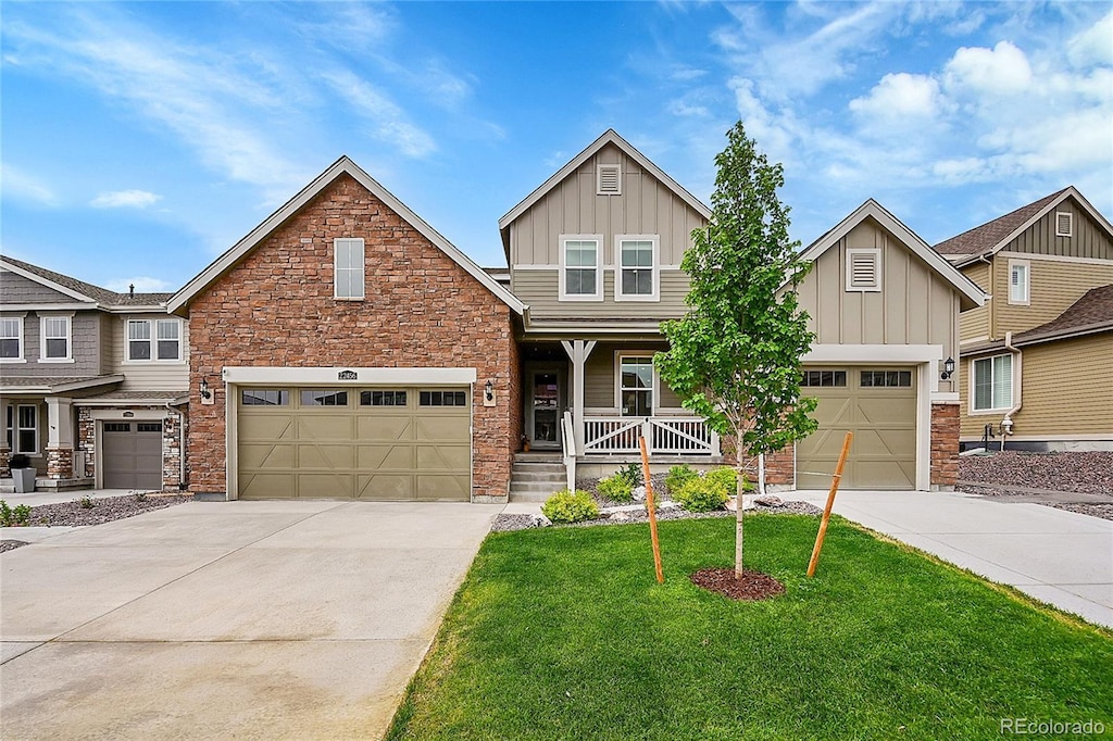 craftsman-style home featuring covered porch, a garage, and a front lawn