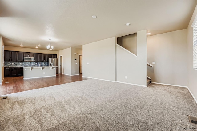 5841 Echo Park Cir, Castle Rock, CO 80104 - unfurnished living room with carpet flooring, stairs, a chandelier, and recessed lighting