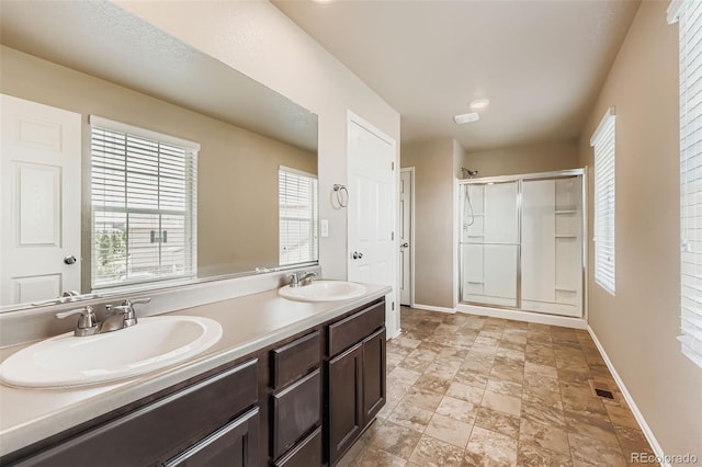 5841 Echo Park Cir, Castle Rock, CO 80104 - full bathroom featuring a stall shower, double vanity, plenty of natural light, and stone finish floors