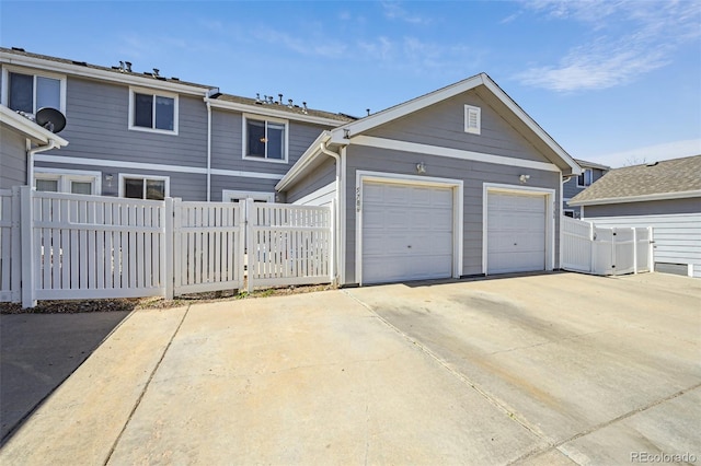traditional-style home featuring a garage, fence, and a gate