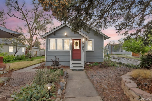 bungalow-style house featuring entry steps and fence