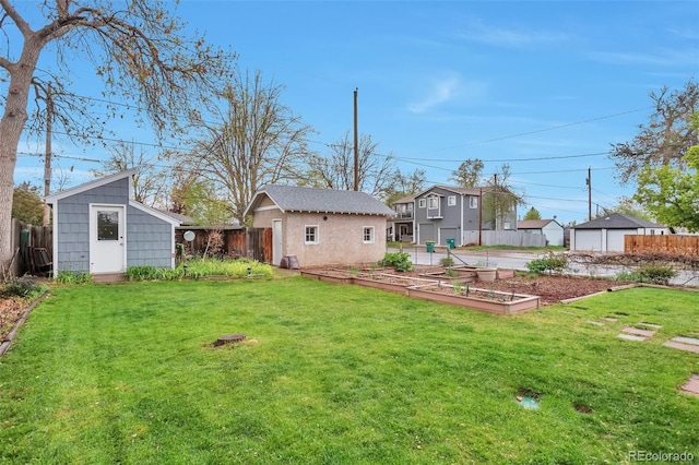 back of house with a vegetable garden, an outbuilding, and a storage shed