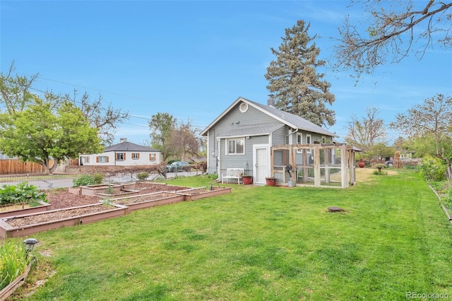 view of yard featuring a vegetable garden, exterior structure, and an outbuilding