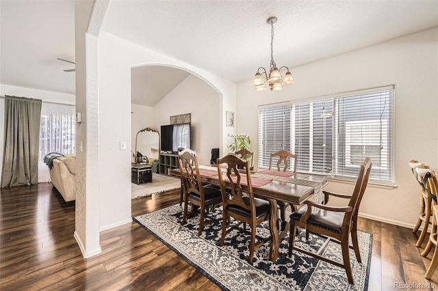 412 Iron St, Brighton, CO 80603 - dining room featuring arched walkways, a chandelier, dark wood-type flooring, and lofted ceiling