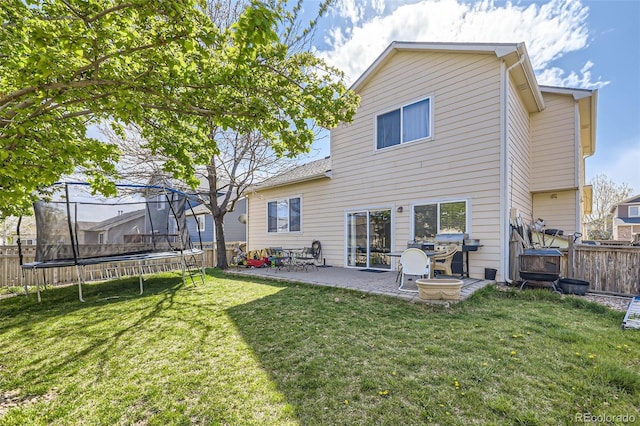 412 Iron St, Brighton, CO 80603 - rear view of property featuring a trampoline, a patio area, and a fenced backyard