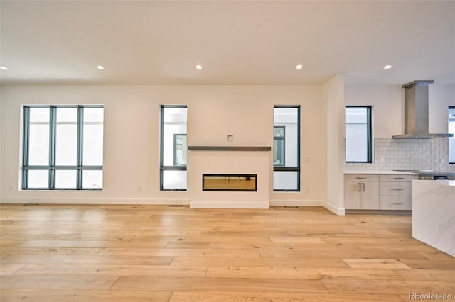 unfurnished living room with plenty of natural light and light hardwood / wood-style flooring