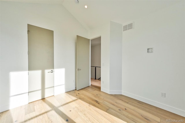 unfurnished bedroom featuring light hardwood / wood-style floors and vaulted ceiling