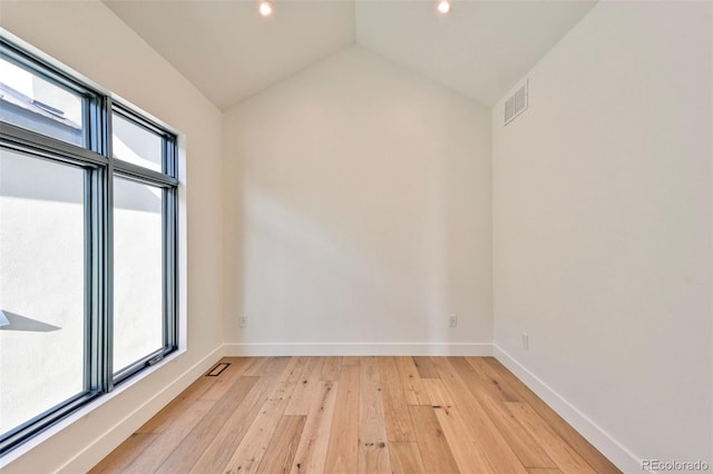 empty room with light hardwood / wood-style flooring and vaulted ceiling