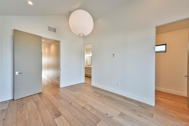 unfurnished room featuring light hardwood / wood-style flooring and high vaulted ceiling