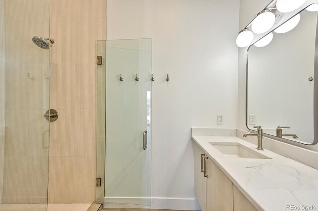 bathroom with vanity and a shower with door