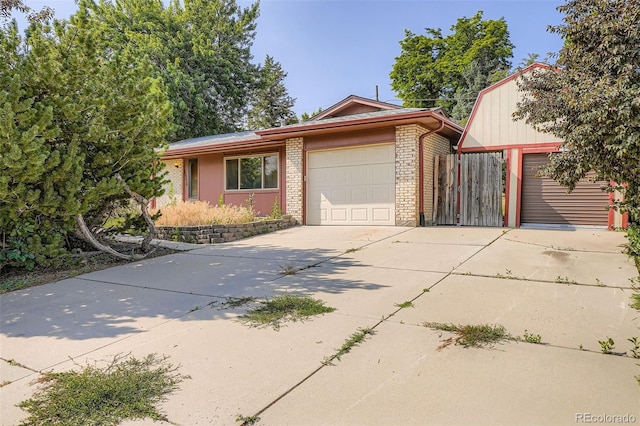 12576 W 7th Ave, Lakewood, CO 80401 - view of front of home with brick siding, an attached garage, and concrete driveway