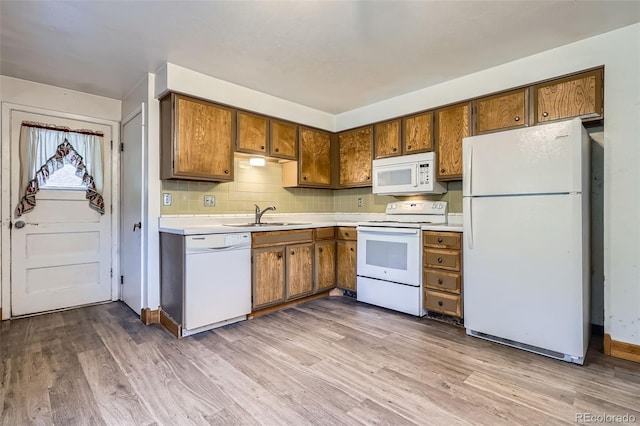12576 W 7th Ave, Lakewood, CO 80401 - kitchen with white appliances, brown cabinets, light countertops, and wood finished floors