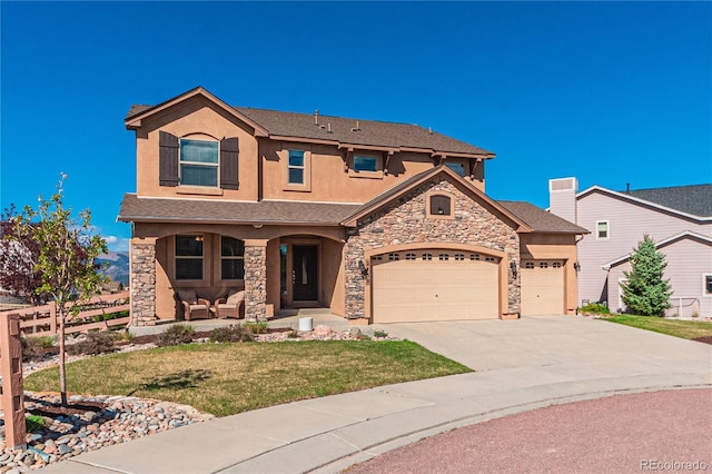 2459 Delicato Ct, Colorado Springs, CO 80921 - view of front of house featuring a garage, stone siding, driveway, a front lawn, and covered porch