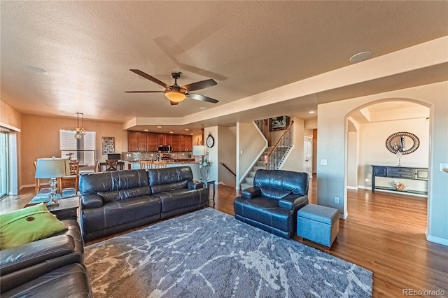 2459 Delicato Ct, Colorado Springs, CO 80921 - living room with a ceiling fan, wood finished floors, a textured ceiling, stairway, and arched walkways
