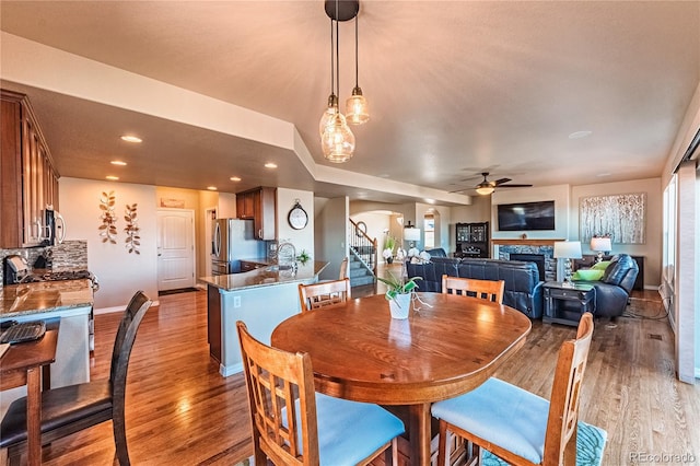 2459 Delicato Ct, Colorado Springs, CO 80921 - dining room featuring arched walkways, ceiling fan, a fireplace, baseboards, and recessed lighting