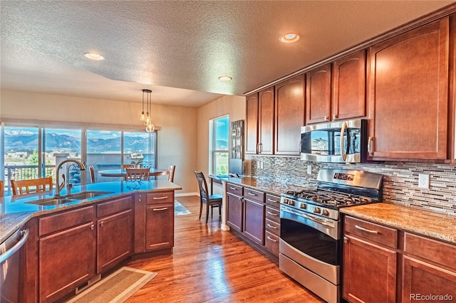 2459 Delicato Ct, Colorado Springs, CO 80921 - kitchen featuring stainless steel appliances, a sink, decorative backsplash, a textured ceiling, and recessed lighting